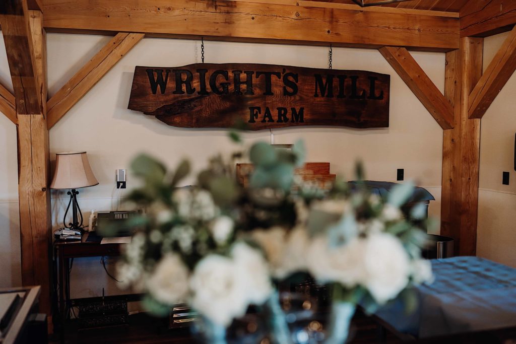 wrights mill farm connecticut barn wedding venue interior bar sign with florals