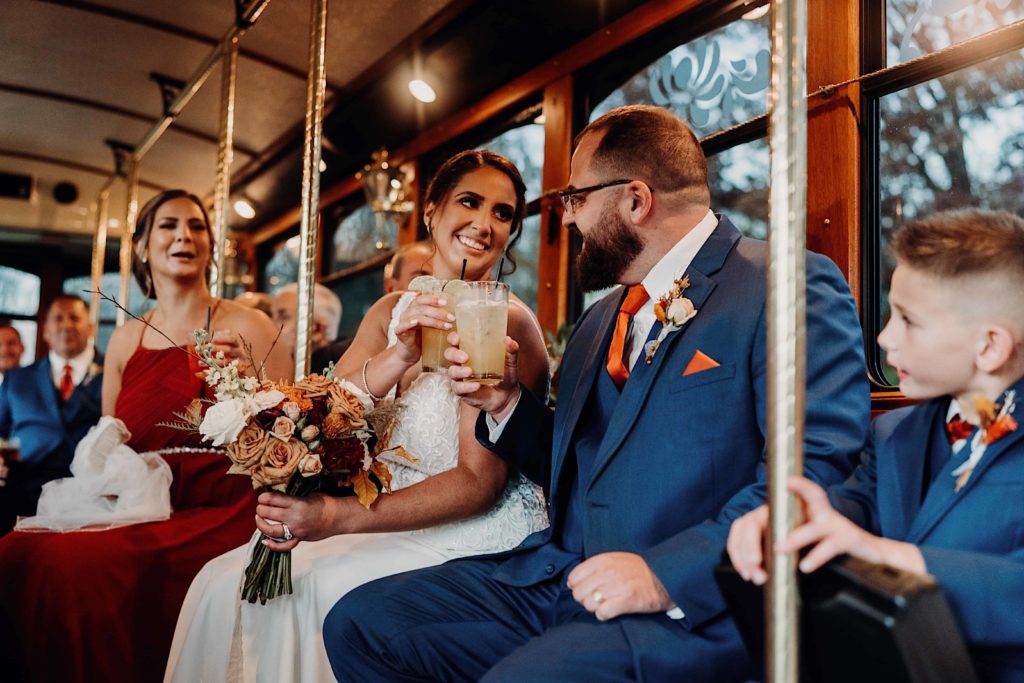 Couple on a trolley after getting married cheersing while looking at each other in a loving way at Sontehurst t Hampton Valley Connecticut wedding venue