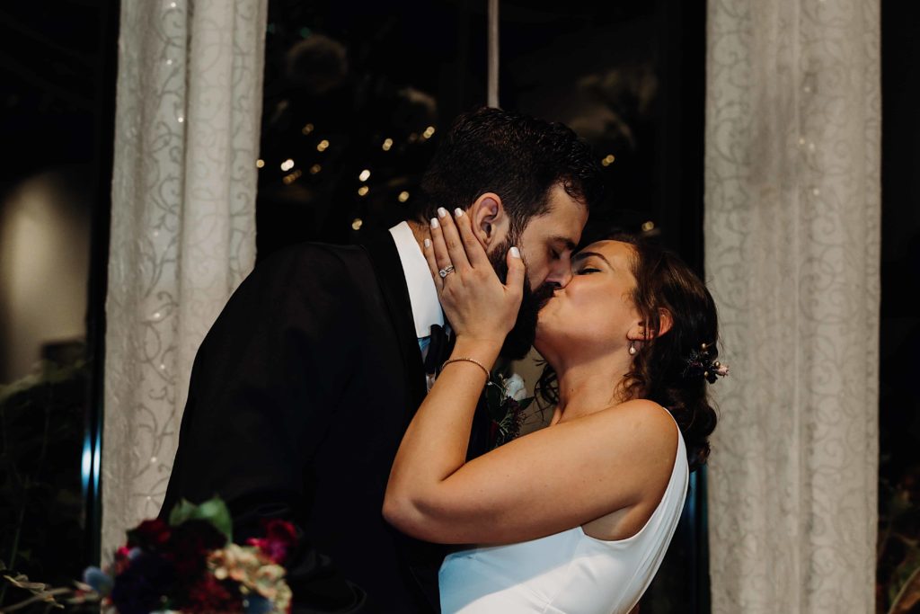 Bride and Groom sharing a kiss after cutting their wedding cake at the Pond House West Hartford Connecticut wedding venue by Ladman Studios