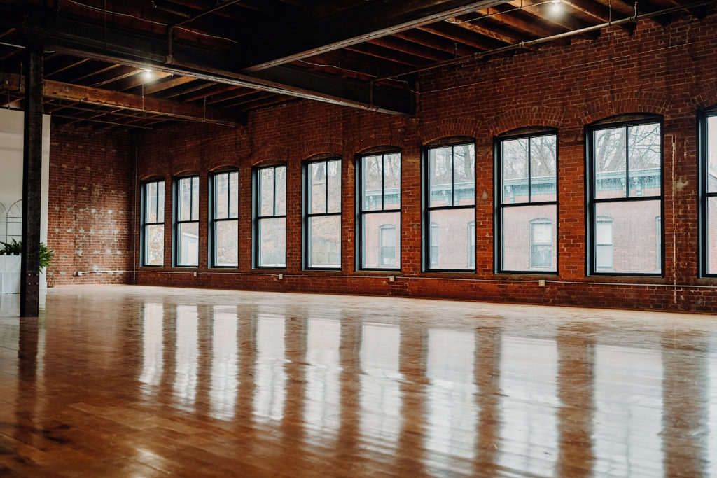 Large wall full of windows letting in sunlight at the sunlight room industrial wedding venue in connecticut