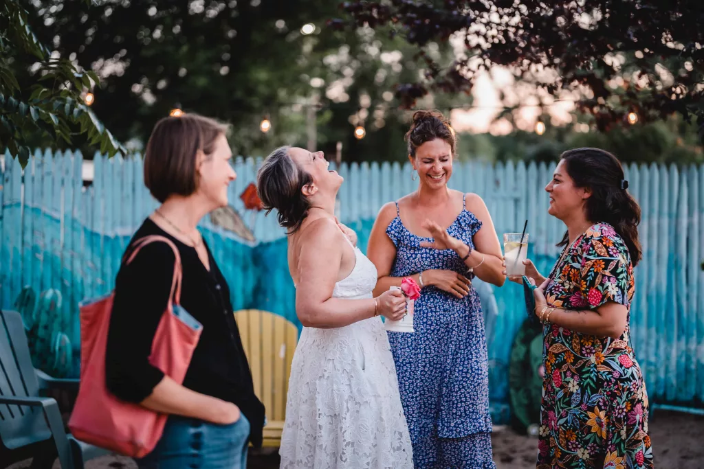 Bride and bridesmaids laughing hysterically at a wedding reception. 