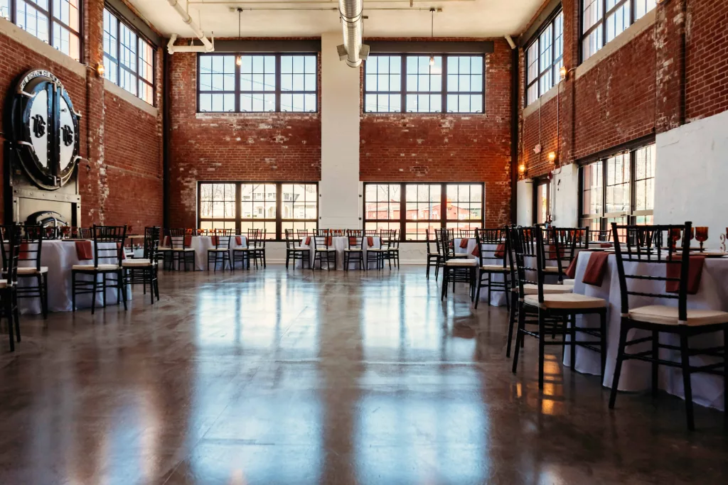 wide interior shot of the Station 97 industrial wedding venue with table and chairs set up
