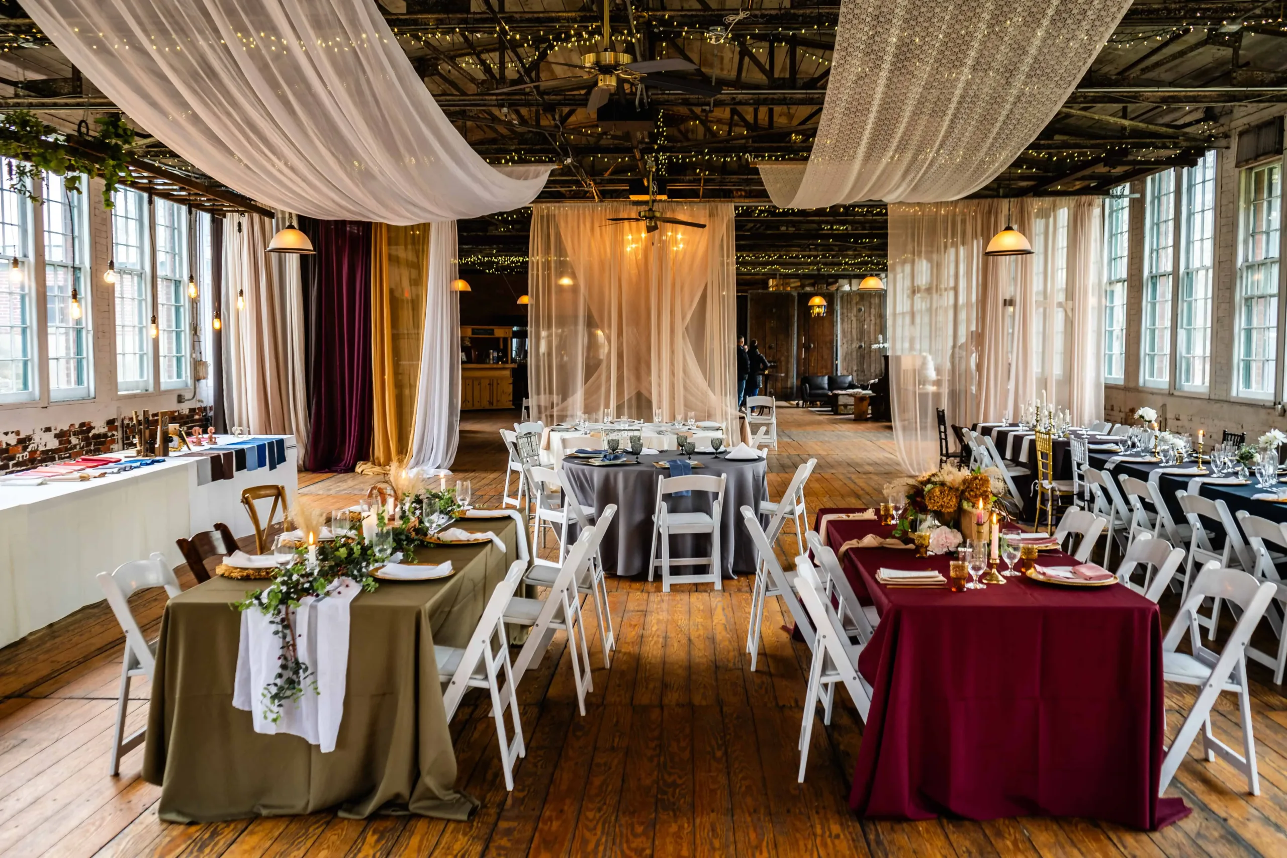 Elegant wedding reception setup at The Lace Factory in Deep River, CT, with beautifully arranged tables, soft drapery, and warm lighting, perfect for a quintessential Connecticut wedding venue.