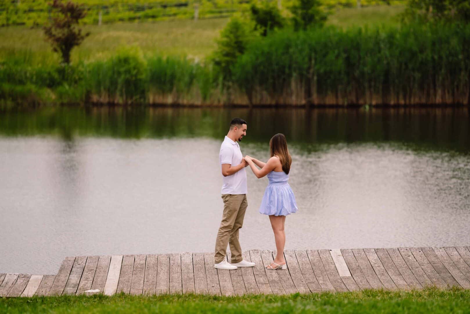 a man and woman standing on a dock by water