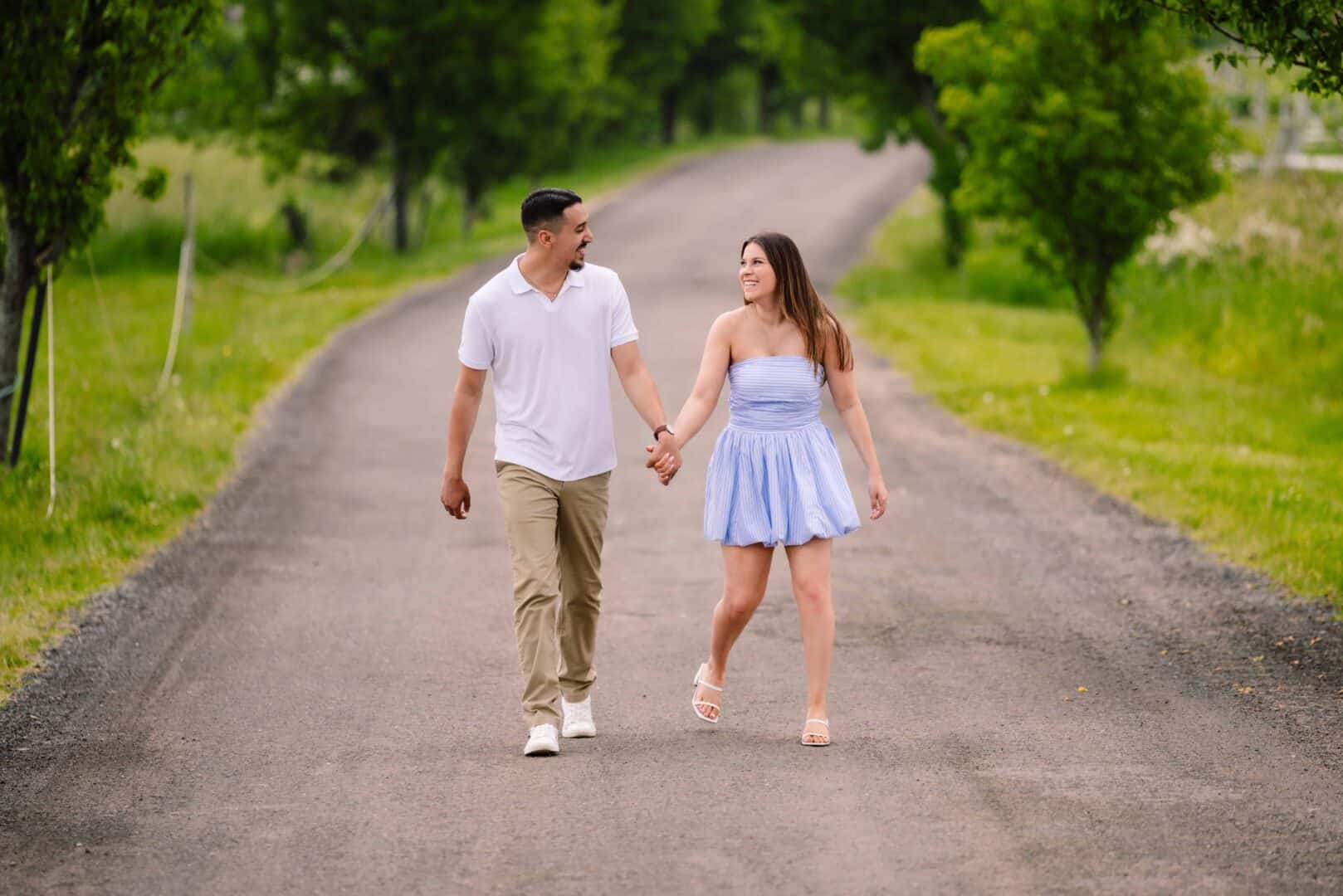 A couple walking down a road holding hands
