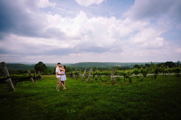 a man and woman hugging in a field of vines at Gouveia Vineyards