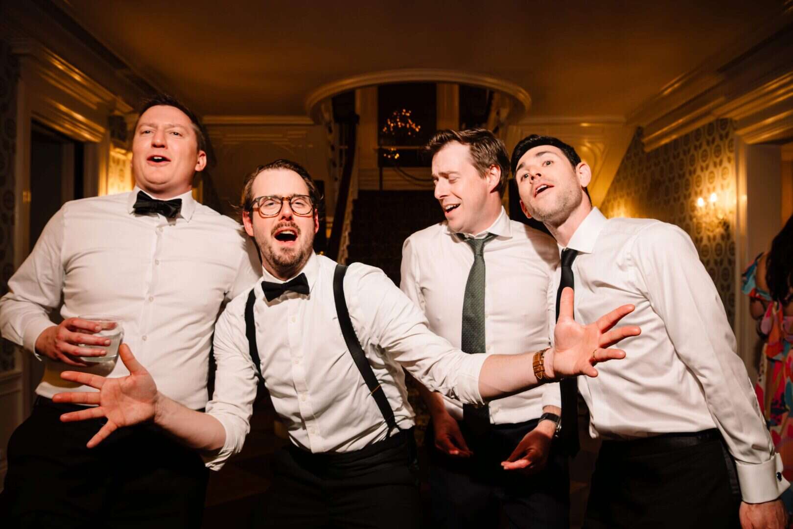 Groomsmen laughing and celebrating together during a Connecticut wedding reception, captured candidly by Ladman Studios.