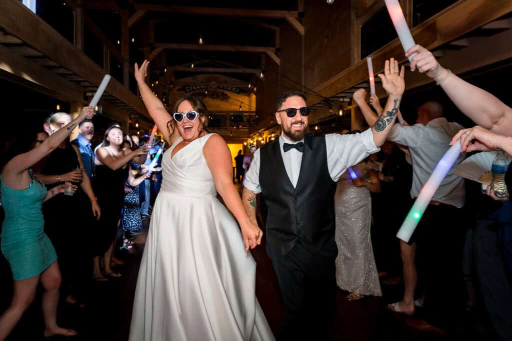 Bride and groom entering the reception surrounded by cheering guests, captured by Ladman Studios, illustrating full-day Connecticut wedding photography coverage.